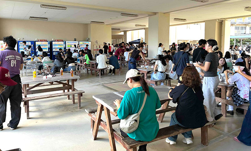 お昼時間になるとＰＴＡの協力のもと多くの参観者がピロティーで「沖縄そば」を美味しそうに食べています