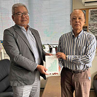 著書の贈呈、金城 毅氏（那覇高28期）