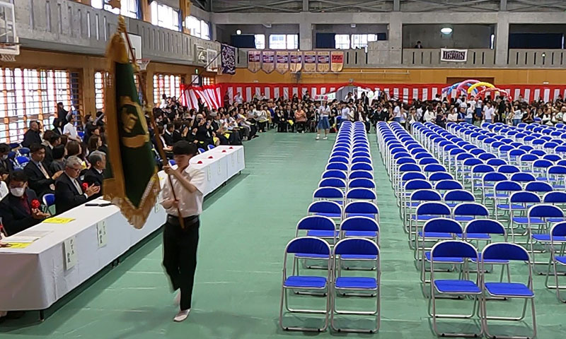 吹奏楽部演奏と保護者の手拍子に合わせて入場